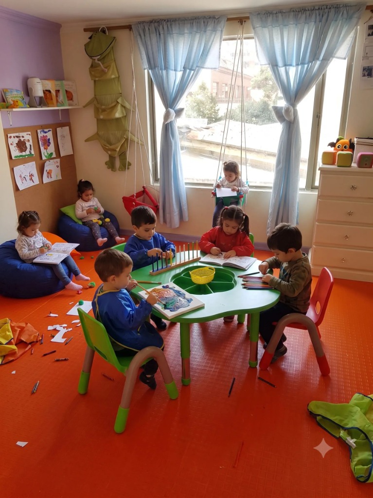 Niños sentados en la mesa pintando y haciendo manualidades