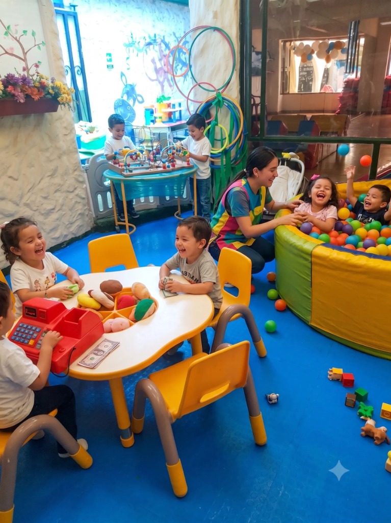 Niños jugando en la piscina de pelotas y mesa de juegos con su maestra